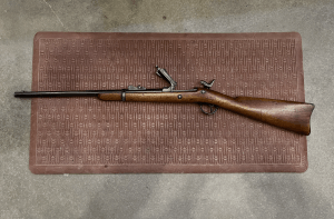 Left side view of a Springfield forty-five seventy cavalry carbine, with the hammer half cocked and the breech block lifted up.